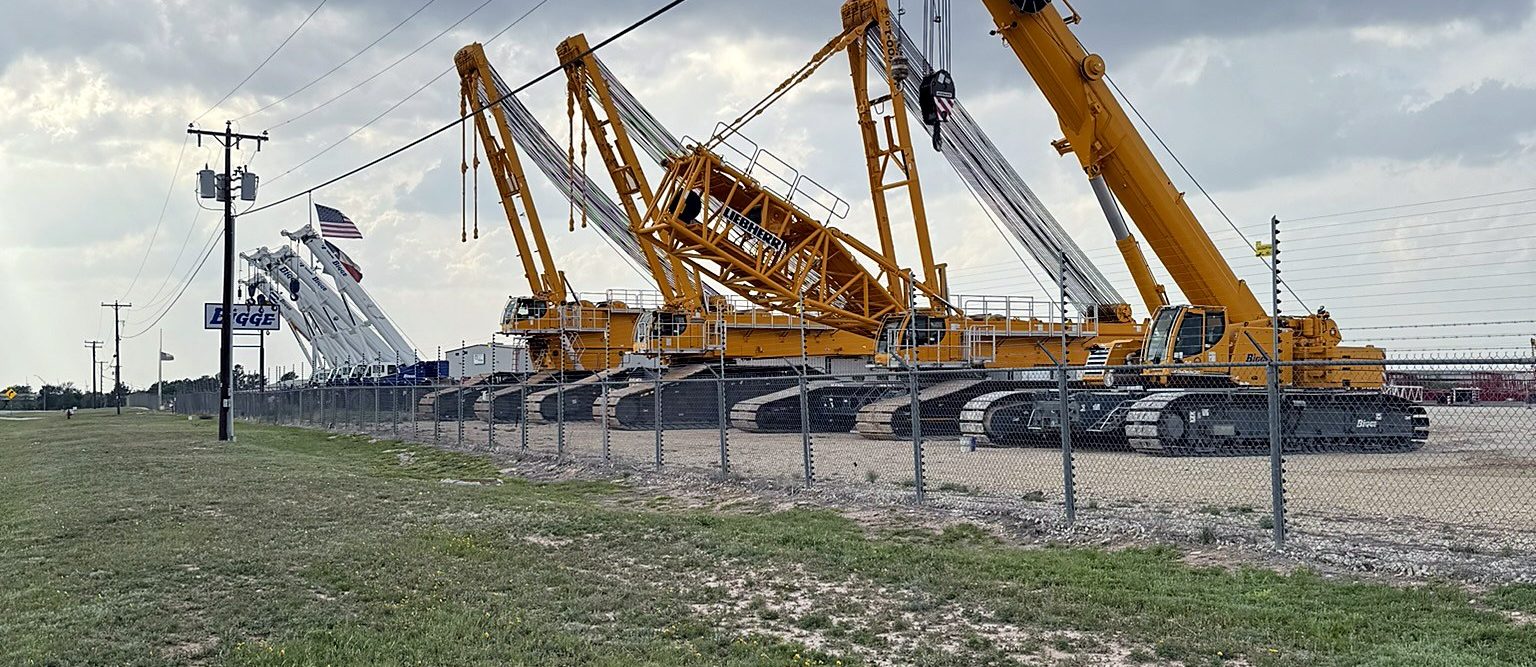 Row of crawler cranes in an equipment yard