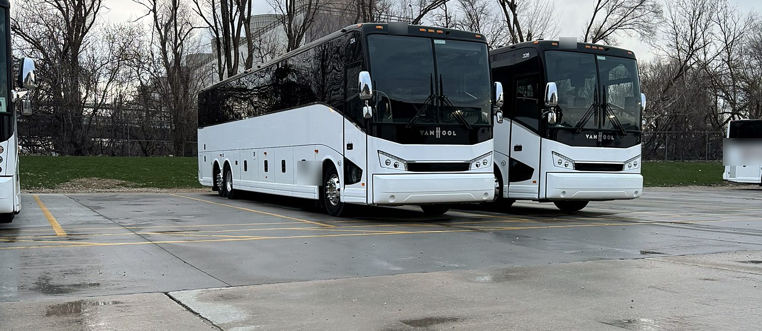 Two motor coaches parked in a lot