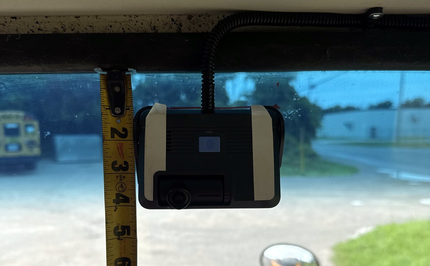 Dash camera mounting height checked with a tape measure
