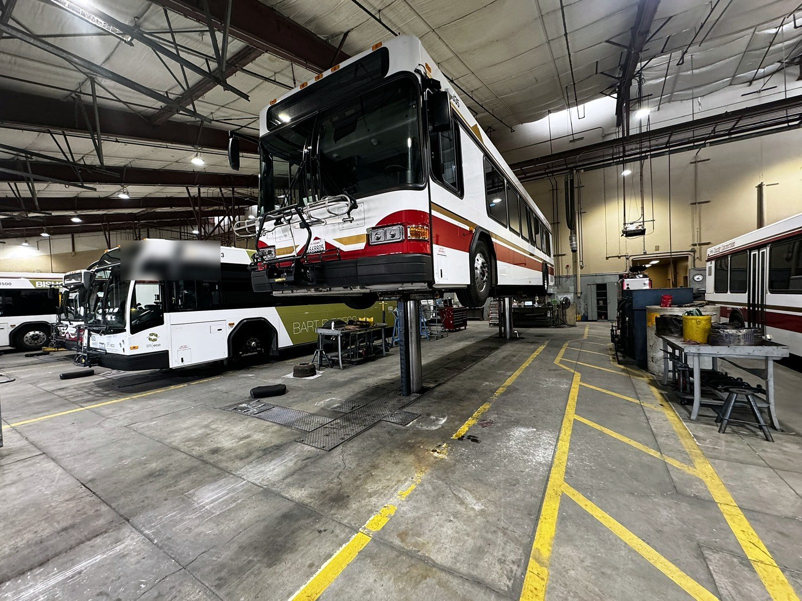 Transit bus up on a hoist in a garage
