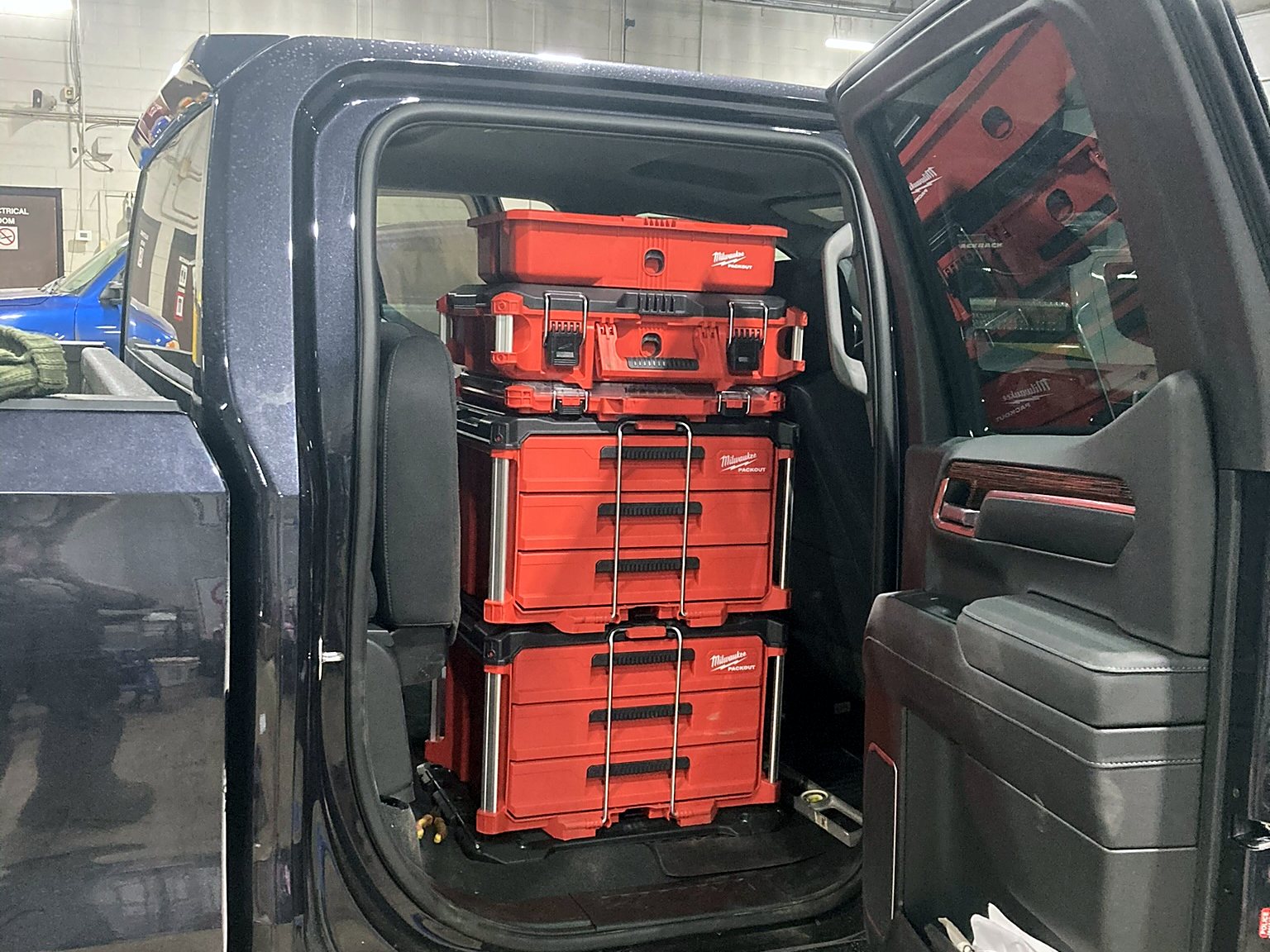 Milwaukee PACKOUT drawers and cases mounted behind the front seats of a crew cab