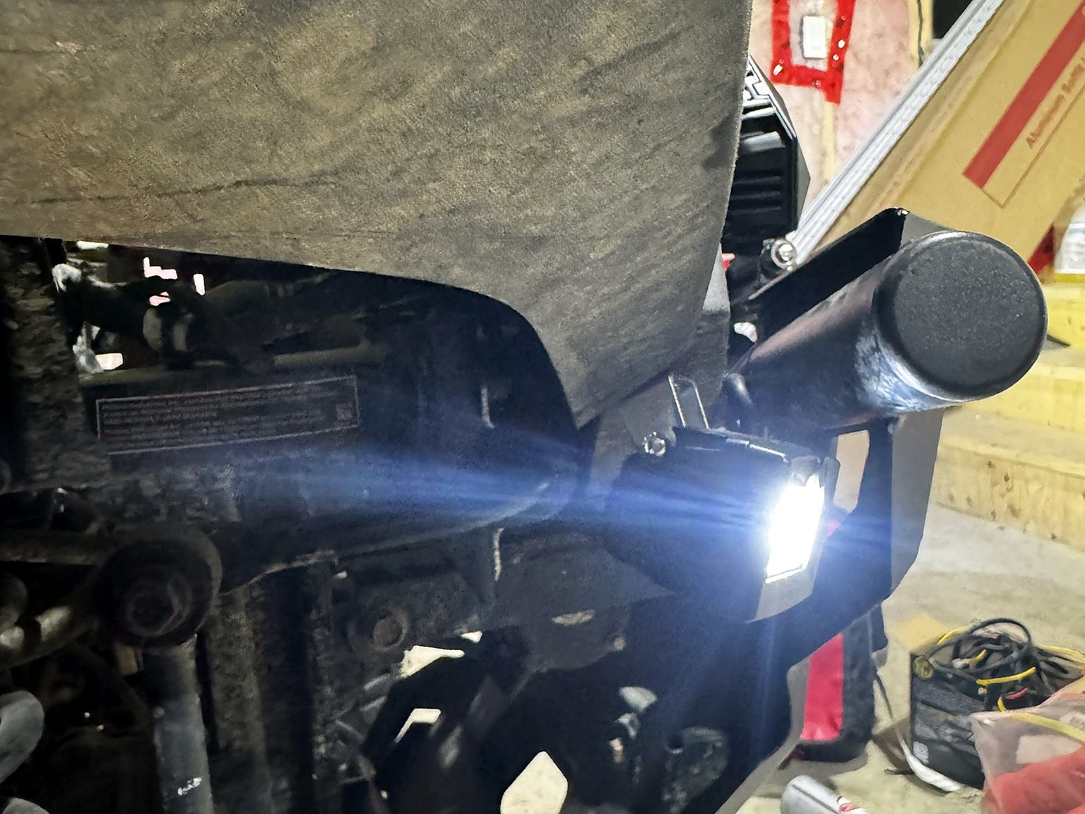 Auxiliary light pod mounted under a UTV fender and switched on