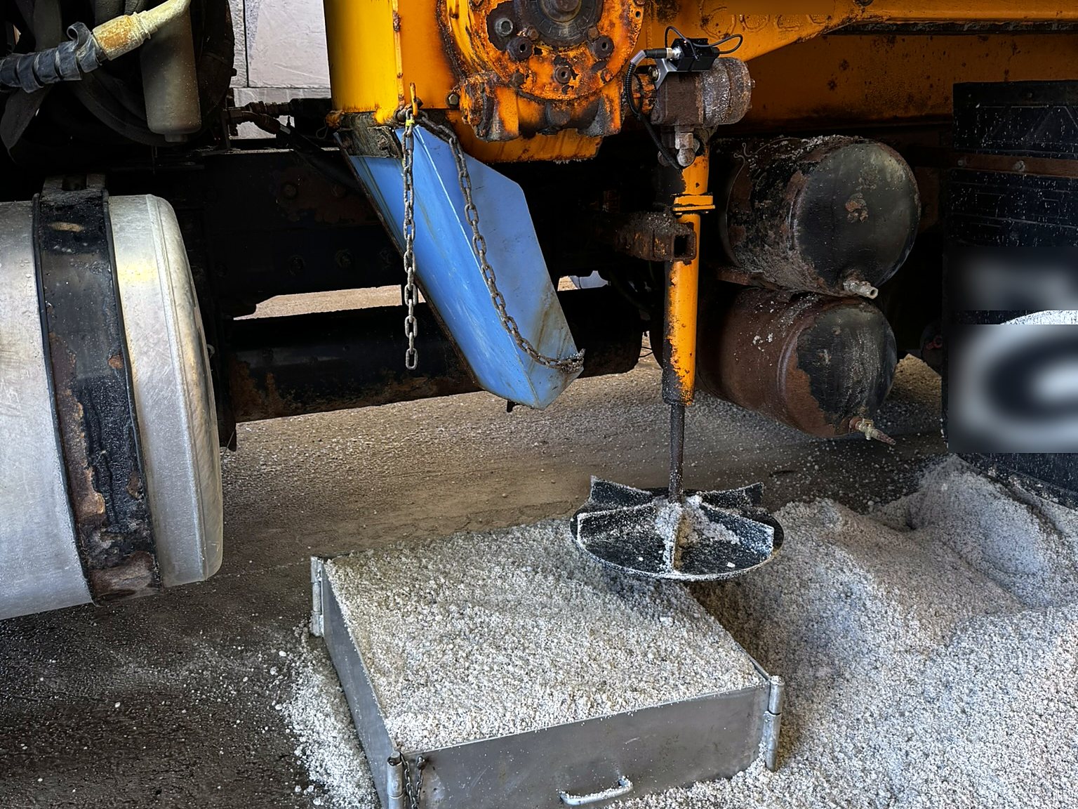 Salt spreader spinner running over a calibration catch tray