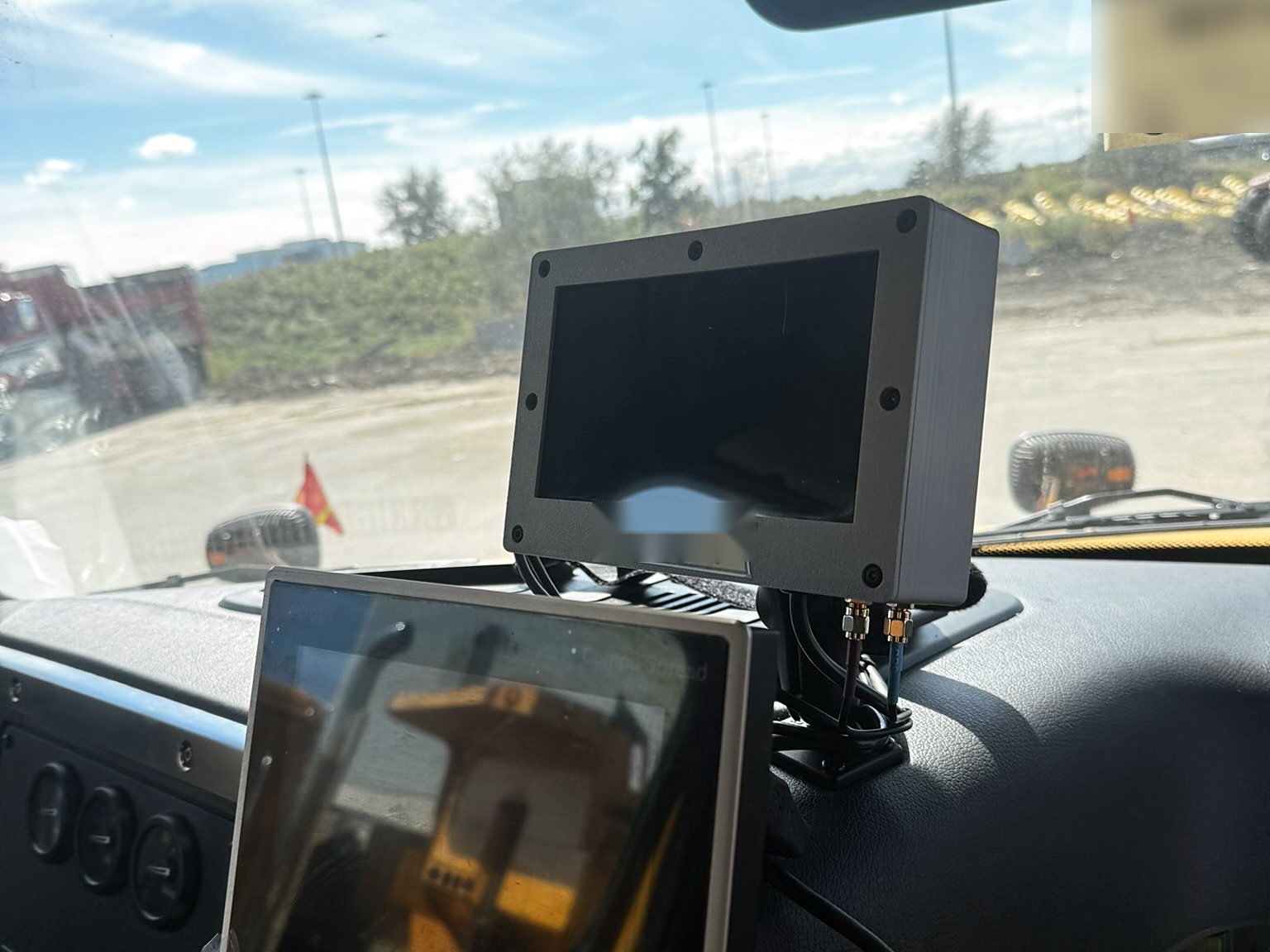 Dash-mounted display and spreader controller installed in a plow truck cab