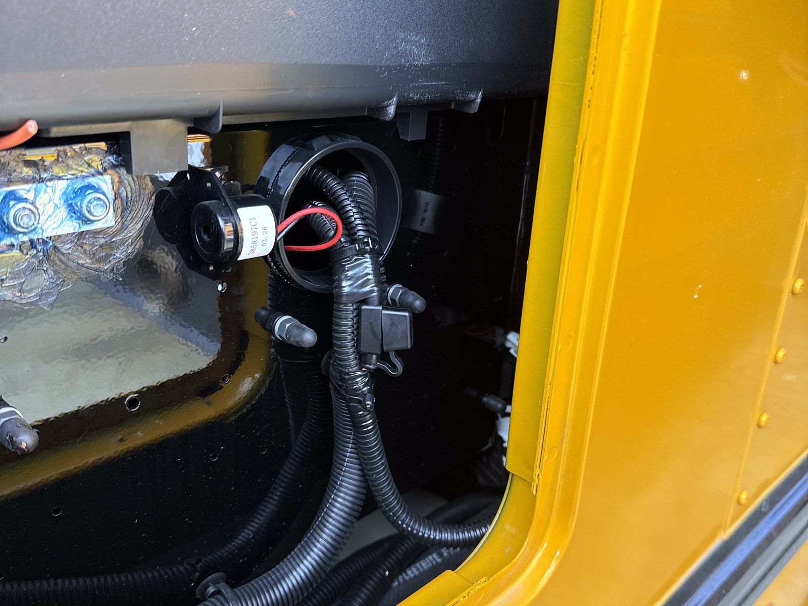 Harness routed and clipped inside a bus body panel